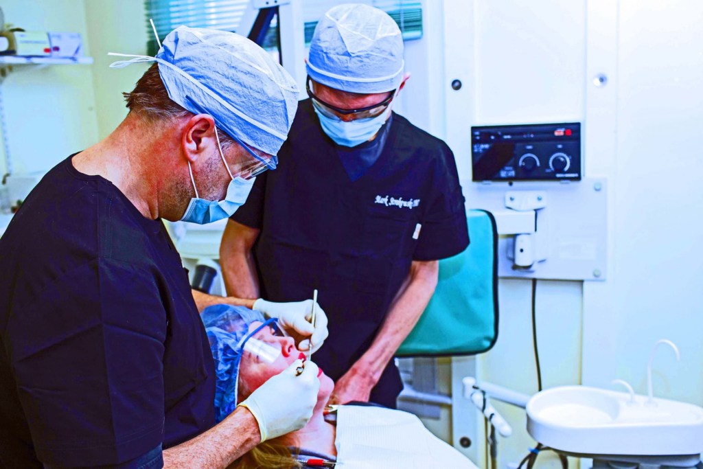 Two staff members taking care of a patient